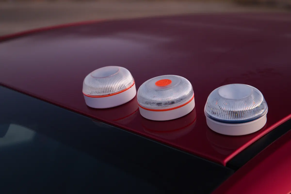 Three V-16 emergency beacons on the roof of a red car
