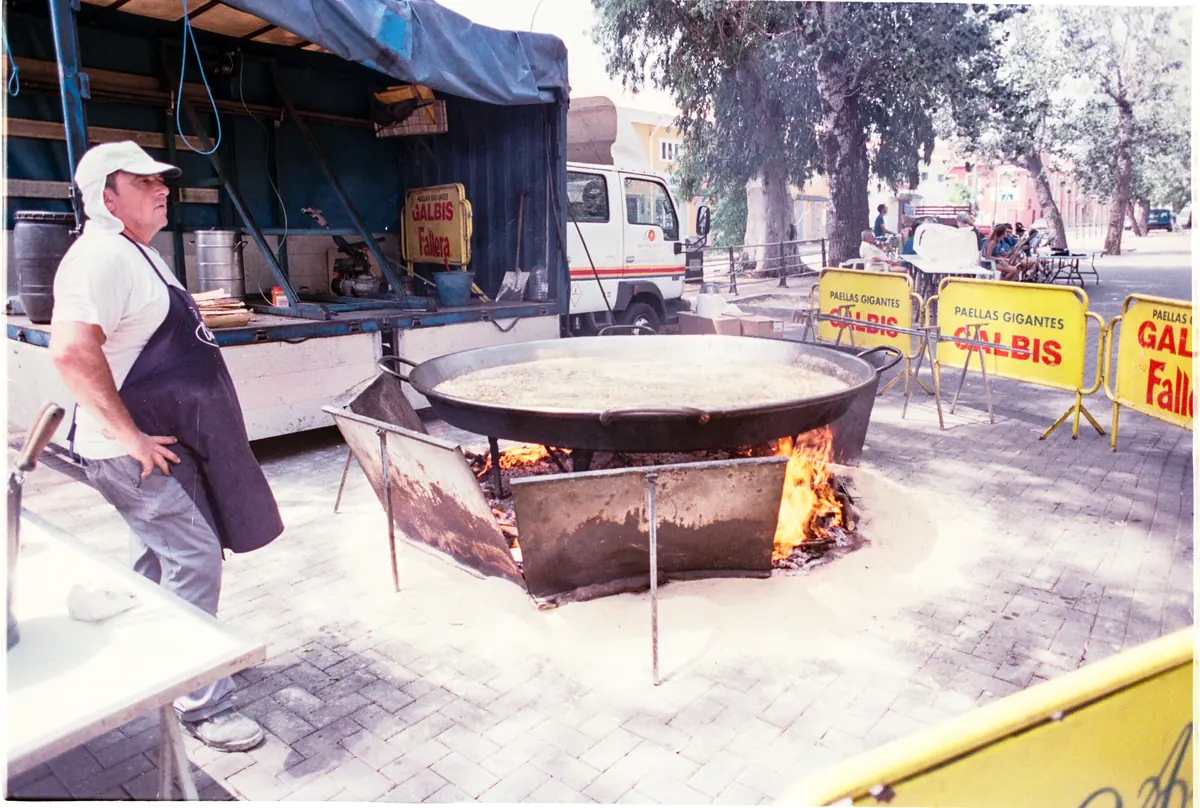 Ein Koch rührt auf dem Markt in Xaló riesige Paellas über dem Holzfeuer